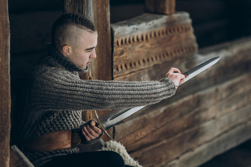 84568100 portrait of strong viking warrior sharpening his sword scandinavian viking cosplay medieval warrior - Preparation for a Day on the Water